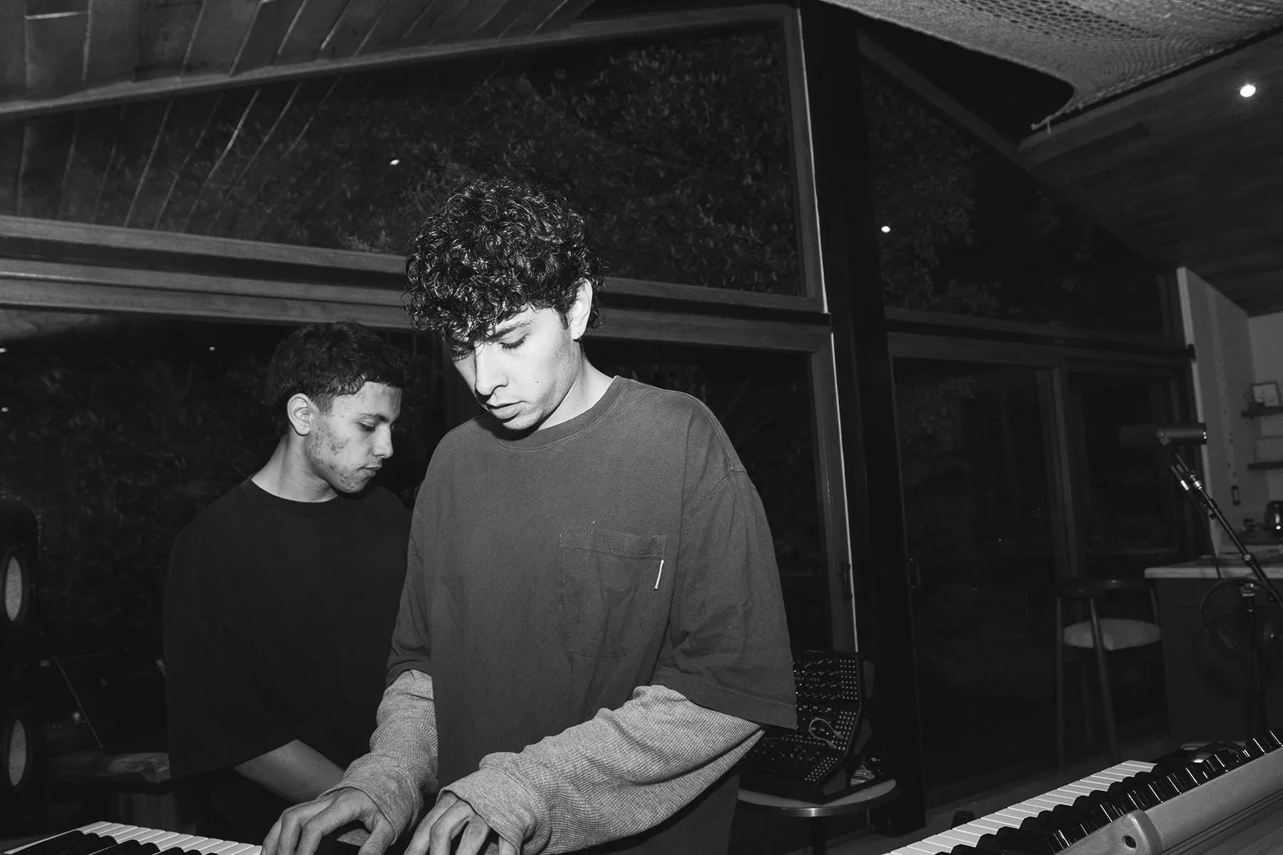 Dos musicos tocando teclados en estudio, foto en blanco y negro