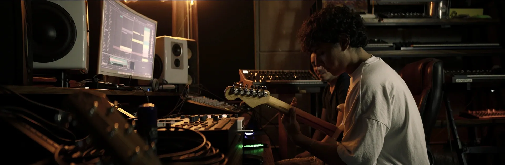 Galo en estudio con guitarra, toma lateral
